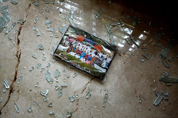 A photograph lies on the floor surrounded by broken glass inside a house after an explosion at a residential neighborhood near the office of India`s main opposition Bharatiya Janata Party, in Bangalore.