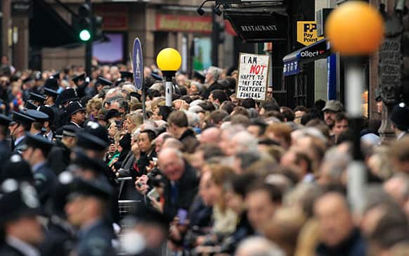 Crowds throng the route before former British Prime Minister Margaret Thatcher`s ceremonial funeral procession in London.