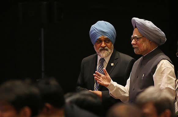 Indian Prime Minister Manmohan Singh speaks with Deputy Chairman of the Planning Commission for India Montek Singh Ahluwalia as he arrives for the Clean Energy Ministerial in New Delhi.