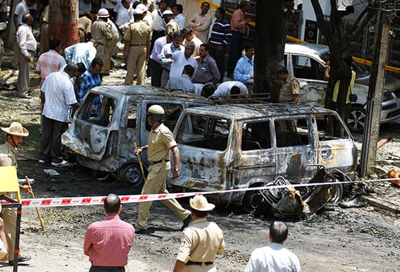 Policemen and officials inspect the site of an explosion at a residential neighborhood near the office of India`s main opposition Bharatiya Janata Party in Bangalore.
