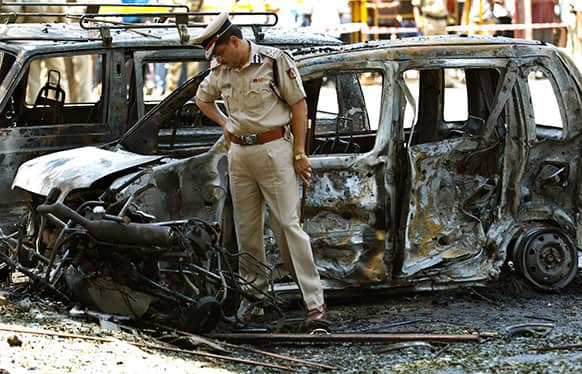 A police officer inspects the site of an explosion at a residential neighborhood near the office of India`s main opposition Bharatiya Janata Party in Bangalore.