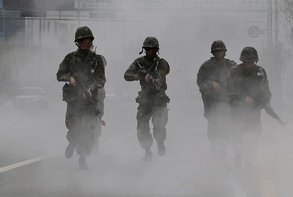 South Korean soldiers holding their machine guns run in smoke during an anti-terror drills at Government Complex in Sejong, south of Seoul, South Korea.
