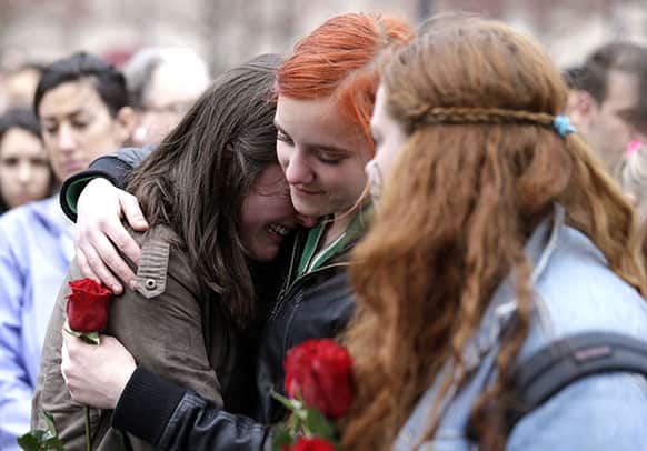 Emma MacDonald, 21, left, is comforted by Rachael Semplice, 22, center, as Juliana Hudson, 23, looks during a vigil for the victims of the Boston Marathon explosions.