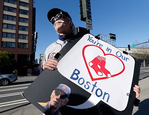 Detroit Tigers` fan Tab Waterman, of Portland, Ore., holds a sign in honor of the victims of the Monday bombings at the Boston Marathon as he stands outside the Seattle Mariners` ballpark before a baseball game against the Tigers in Seattle.