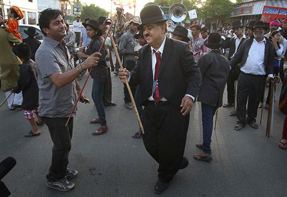 Members and supporters of the Charlie Circle, a Charlie Chaplin fan-club, dance during the annual parade to celebrate the birthday of Charlie Chaplin in Adipur, Gujarat.