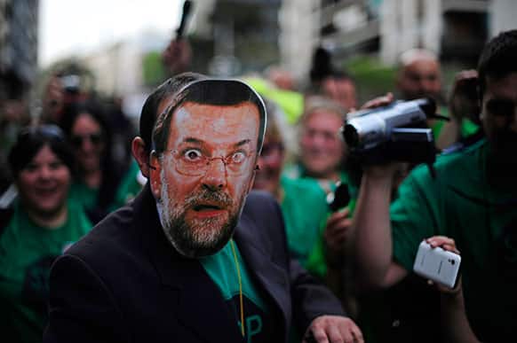 A man from Members of the Mortgage Victims` Platform (PAH) protests with a mask of Spain`s Prime Minister Mariano Rajoy against evictions in Barcelona.