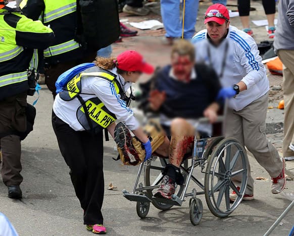 Medical workers aid an injured man at the 2013 Boston Marathon following an explosion in Boston.