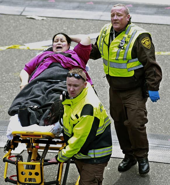 Medical workers aid an injured woman at the finish line of the 2013 Boston Marathon following two explosions there.