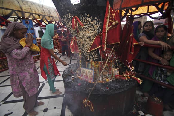 Hindu devotees offer prayers as others stand in a queue inside the Kali Temple on during Navratri festival in Jammu. Navratri, or the festival of nine nights, is dedicated to the worship of various goddesses.