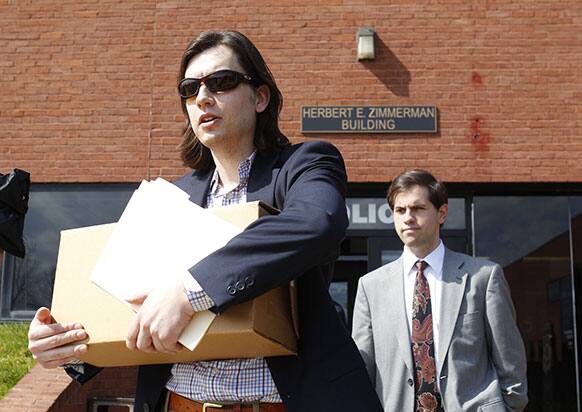 David A. Lewis carries a box of guns that were returned to him by the Amherst Police in Amherst, N.Y.