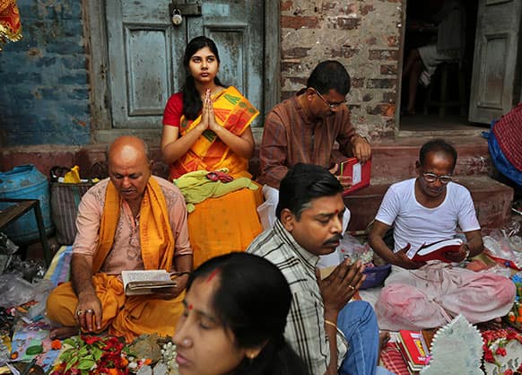 Indian Hindu devotees pray as priests bless their business ledgers during Bengali New Year celebrations in Kolkata.