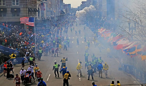 People react as an explosion goes off near the finish line of the 2013 Boston Marathon in Boston. Two explosions went off at the Boston Marathon finish line on Monday, sending authorities out on the course to carry off the injured while the stragglers were rerouted away from the smoking site of the blasts.