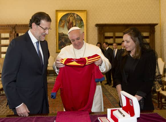 Pope Francis is presented with a jersey of the Spanish national soccer team during his private audience with Spain`s Prime Minister Mariano Rajoy and his wife Elvira Fernandez Balboa at the Vatican.