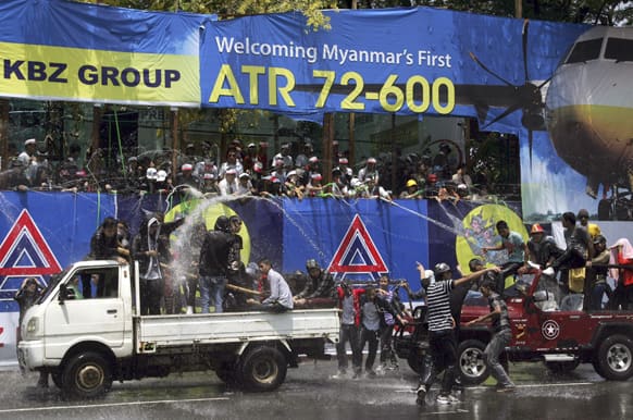 Revelers on vehicles are sprayed with water during traditional Thingyan celebrations in Yangon, Myanmar.