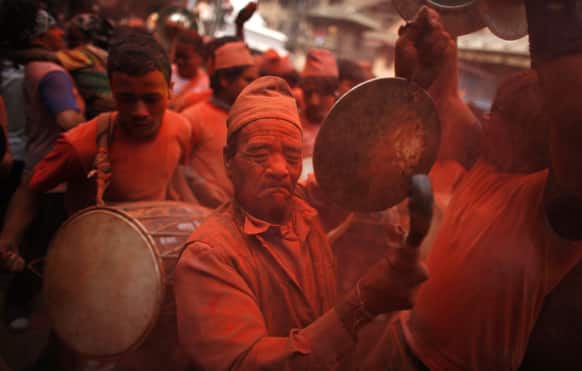 Nepalese devotees, covered in vermilion powder, beat drums and dance during Sindur Jatra festival in Thimi, on the outskirts of Katmandu.