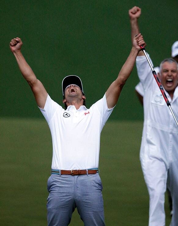 Adam Scott, of Australia, celebrates with caddie Steve Williams after making a birdie putt on the second playoff hole to win the Masters golf tournament in Augusta, Ga.