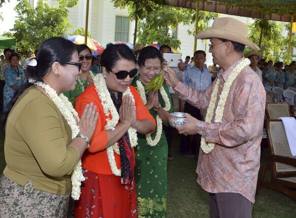 Myanmar President Thein Sein, right, sprinkles water to visitors during celebrations of the traditional water festival outside his residence in Naypyitaw, Myanmar.
