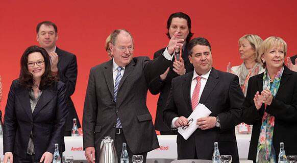 Peer Steinbrueck, of the German Social Democratic Party, SPD, the challenger of chancellor Angela Merkel in the September elections,first row second left, waves to delegates as he arrives at a party convention of the German Social Democratic Party in Augsburg, Germany.
