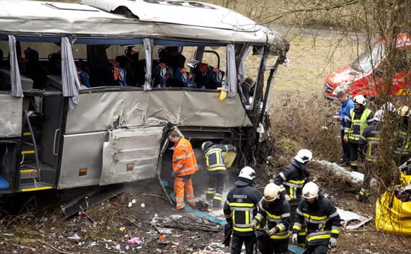 Police officers go over evidence and personal items at the site of a bus crash in Ranst, Belgium. The Polish bus carrying Russian youngsters crashed through guardrails and off a highway onto a field below near the port city of Antwerp on Sunday, killing at least five people and leaving five more critically injured.
