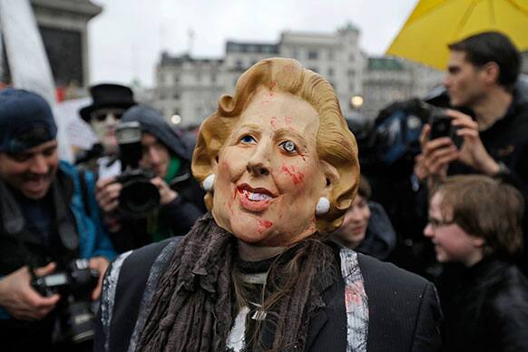 A protester wears a mask depicting former British Prime Minister Margaret Thatcher during a party in central London`s Trafalgar square.
