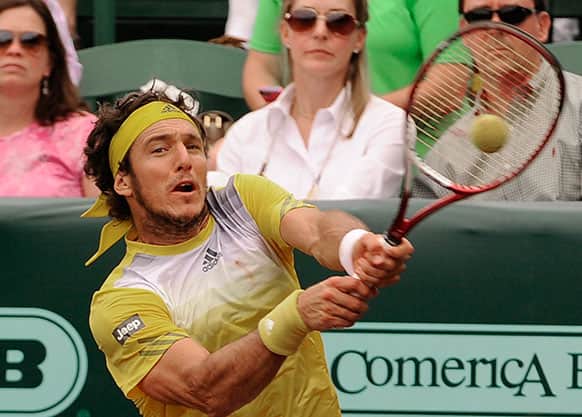 Juan Monaco, of Argentina, returns a shot in the third set against John Isner, of the United States, in their semifinal tennis match at the U.S. Men`s Clay Court Championship.