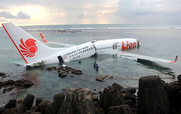 The wreckage of a crashed Lion Air plane sits on the water near the airport in Bali, Indonesia. The plane carrying more than 100 passengers and crew overshot a runway on the Indonesian resort island of Bali on Saturday and crashed into the sea, injuring nearly two dozen people, officials said.