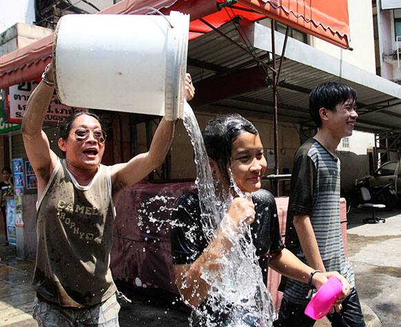 A Thai man pours a bucket of water on a girl during the Songkran festival to celebrate Thai New Year in Bangkok.