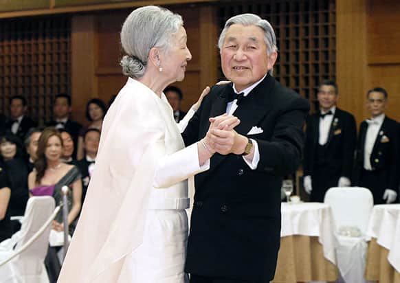 Japanese Emperor Akihito, right, and Empress Michiko dance during a dinner party for a charity in Tokyo.