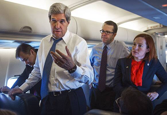 US Secretary of State John Kerry, center, talks with reporters aboard his government aircraft shortly after departing Seoul Air Base, Seoul, South Korea, for Beijing, China.