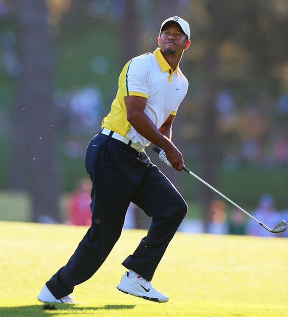 Golfer Tiger Woods reacts to his recovery shot from off the fairway over the trees to the 17th green during the second round in the Masters golf tournament in Augusta, Ga.