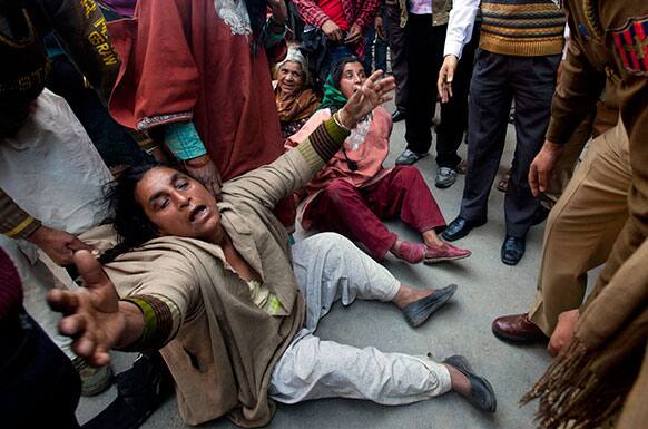 A Kashmiri Muslim woman relative of Mohammad Ismail Shah shout slogans against the police as they block a road during a protest in Srinagar.