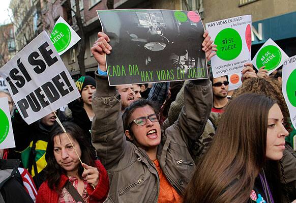 Protestors shout slogans and carry banners reading