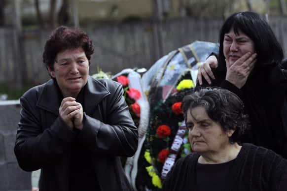 People react prior to a mass funeral of the victims of a shooting in the village of Velika Ivanca, some 50 kilometers (30 miles) southeast of Belgrade, Serbia. The village is preparing for the funerals of thirteen victims of a shooting that happened on Tuesday, April 9, 2013.