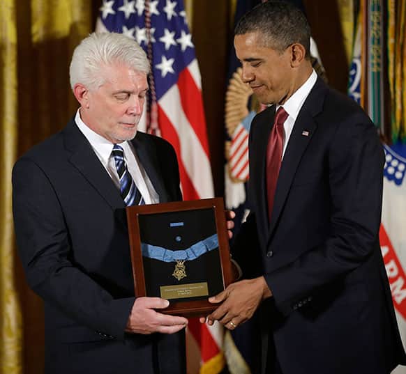 President Barack Obama stands with Ray Kapaun, left, nephew of Chaplain Capt. Emil J. Kapaun, US Army, as he awards the Medal of Honor posthumously to Chaplain Kapaun in the East Room of the White House.