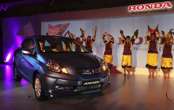 Dancers perform as Honda`s new Amaze diesel engine car rolls in during its launch in New Delhi.