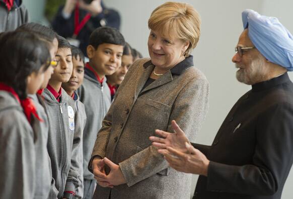German Chancellor Angela Merkel and Indian Premier Manmohan Singh talk to pupils of an Indian school class as they meet for the Germany-India summit at the chancellery in Berlin.