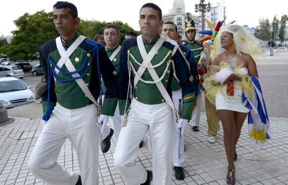 A same sex marriage activist dressed as a bride, right, jokes with congressional guards outside Parliament where lawmakers are expected to vote on a same sex marriage law in Montevideo, Uruguay.