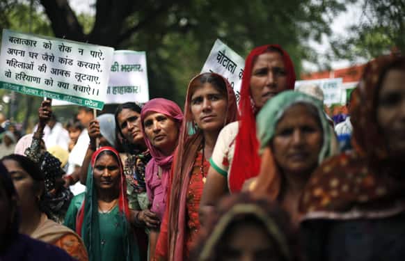 Women from Haryana listen to a speaker, unseen, while participating in a rally criticizing the rise in crimes against women in New Delhi.