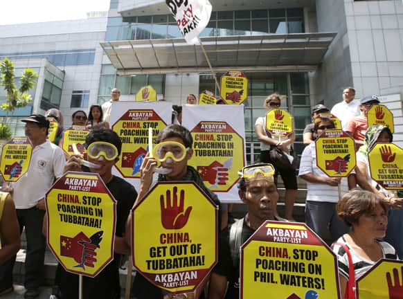 Protesters display placards as they picket the Chinese Consulate at the financial district of Makati city, Manila, to protest the grounding of a Chinese fishing vessel off Tubbataha Reef, a World Heritage Marine Site, in Southwestern Philippines.