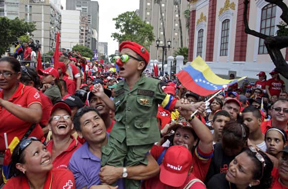 A boy dressed in military fatigues is held up by a man at a campaign rally for Venezuela`s acting president and ruling party presidential candidate Nicolas Maduro in Caracas.