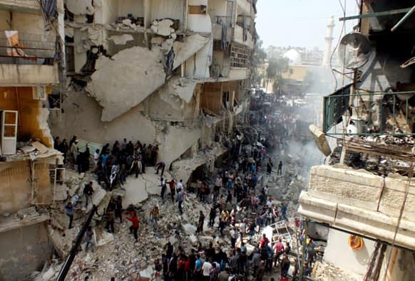 Syrian citizens searching for bodies in the rubble of damaged buildings that were attacked by Syrian forces airstrikes, in the al-Ansari neighborhood of Aleppo, Syria.