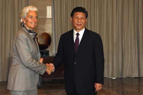 International Monetary Fund (IMF) managing director Christine Lagarde, left, and China`s President Xi Jinping pose for photos before their meeting at the annual Boao Forum in Boao, in southern China`s Hainan province.