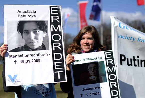 Demonstrators protest with posters of journalists Anastasia Baburova killed in 2009 & of Anna Politkovskaya killed in 2006, outside the Congress centrum in Hannover, were German chancellor Angela Merkel & Vladimir Putin are expected to meet & to deliver speeches at the Hannover Industrial Fair.