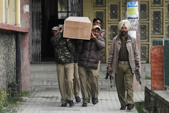 Policemen carry a coffin containing the body of a female British tourist after conducting medical examination in Srinagar.