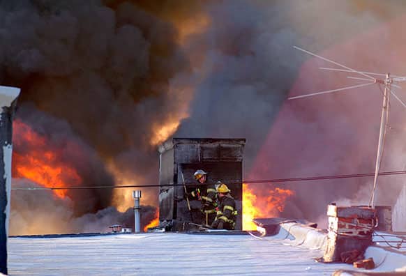 Firefighters battle a blaze in Philadelphia on Saturday, April 6, 2013, that burned a fabric shop, upstairs apartments and a neighboring boutique.