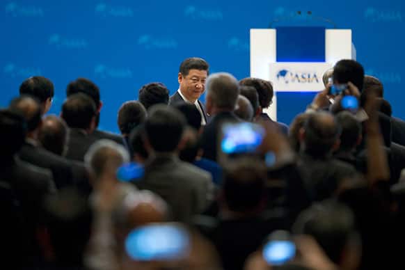 China`s President Xi Jinping, center back, walks to his seat as he arrives at the opening ceremony of the annual Boao Forum in Boao, in southern China`s Hainan province.