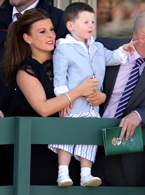 Coleen Rooney, wife of soccer player Wayne, and her son Kai, during the first race of the Grand National horse race meeting at Aintree Racecourse, Liverpool, England.