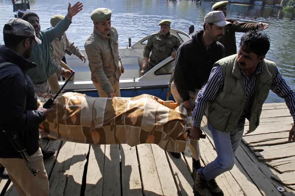 Policemen carry the dead body of a female British tourist on the banks of the Dal Lake in Srinagar. The British woman was found dead in a pool of blood in a houseboat in Kashmir early Saturday and a Dutchman has been arrested, police said.