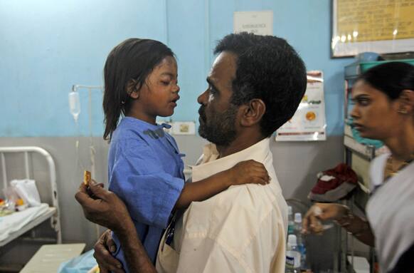 A social worker talks to an injured girl Sandhya Thakur whose mother was killed in a building collapse, at a hospital on the outskirts of Mumbai.