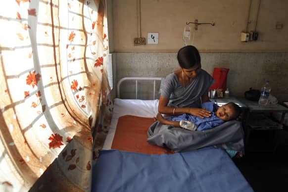 A hospital worker cares for a 10-month-old child injured in a building collapse, at a hospital on the outskirts of Mumbai.
